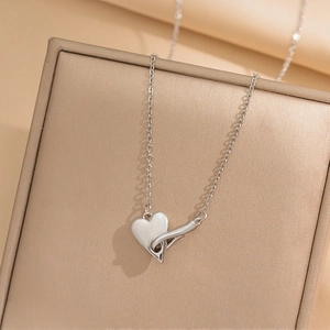 Elegant silver heart pendant necklace on beige jewelry box with O-chain design