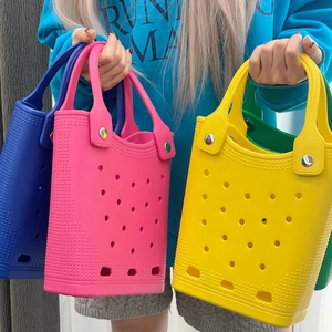 Detailed view of colorful EVA beach tote bags in blue, pink and yellow with hole pattern
