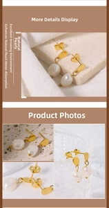 Detailed view of vintage gold hoop earrings with white baroque natural pearls on marble