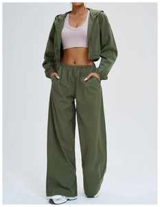 Three-piece women's set with olive jacket, pink crop top, and wide-leg sports trousers