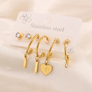 Dettaglio del set di orecchini a cuore e lettere in acciaio placcato oro 18k