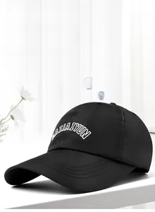 Macro view of breathable quick-dry fabric and white embroidery on a black sun hat