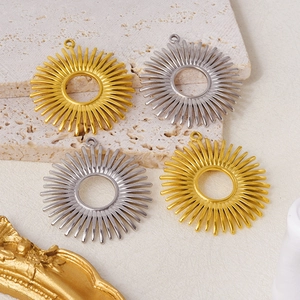 Flat lay of sunburst pendant charms in gold and silver stainless steel for DIY jewelry