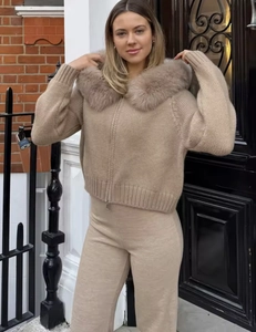 Close-up of beige knitted two-piece set featuring a luxury faux fur collar and hood