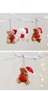 Detailed view of plush Christmas teddy bears in Santa hats holding festive red gift boxes