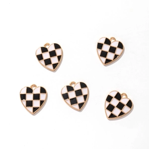 Detailed view of heart-shaped checkered enamel pendants with gold metal frames for DIY jewelry