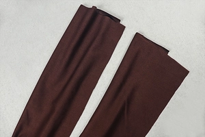 Detail der dunkelbraunen Manschetten aus glattem Webstoff am rückenfreien Maxikleid