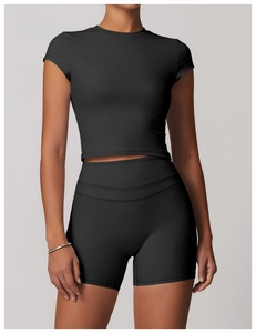 Close-up of black brushed athletic fabric on fitted yoga tee and high-waist shorts set
