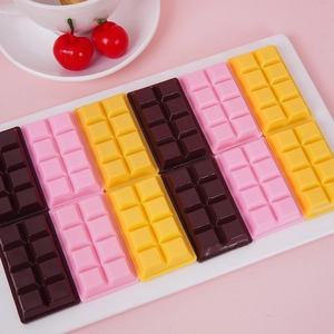 Realistic PVC chocolate bar keychains in pink, yellow, and brown set on a tray