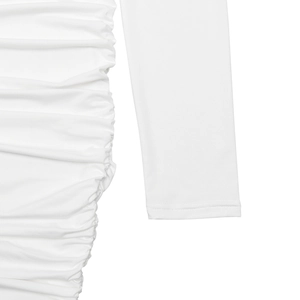 Detail of white dress featuring side ruching and clean hemline on long sleeves