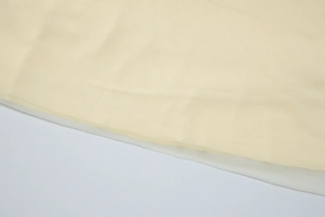Macro shot of layered beige mesh fabric showing fine texture and transparent net structure