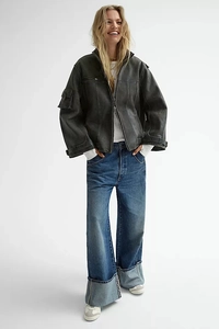 Close-up of wide cuffed hem detail on vintage washed straight leg denim jeans