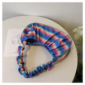 Detail of colorful rainbow gradient pleated shoulder bag with soft satin texture