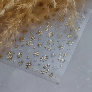 Macro di adesivi per unghie 3D dorati con fiocchi di neve e scritte metalliche