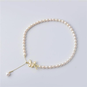 Detailed view of freshwater pearl necklace with gold butterfly clasp and pearl tassel
