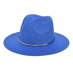 Detail of blue fedora straw hat featuring a black band and gold metal hardware ornament