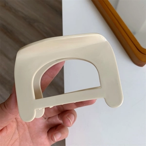Close-up of cream ivory geometric hair claw clip with large rectangular hollow design