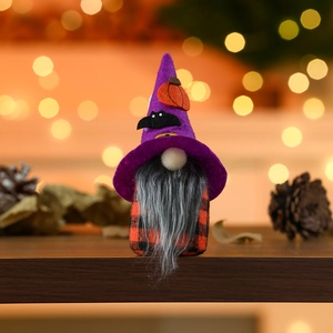 Detail of Halloween gnome with purple wizard hat and orange pumpkin on dark wood