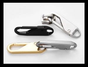 Macro view of universal metal zipper pulls in silver, gold, and black for luggage repair
