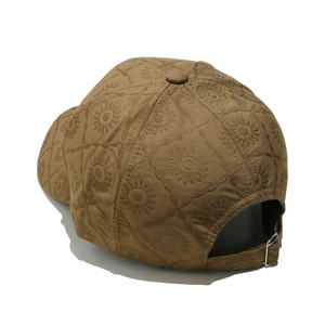 Détail de broderie de tournesol sur casquette beige avec boucle de réglage en métal