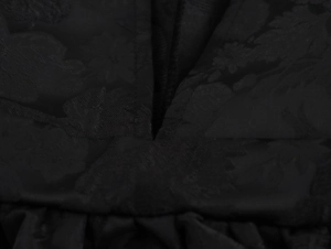 Detailansicht aus nächster Nähe von schwarzem Jacquard-Stoff mit geprägtem Blumenmuster