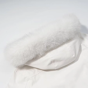 Detailed close-up of a white hooded jacket featuring a fluffy faux fur collar and fabric texture