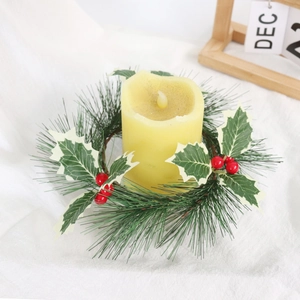 Christmas candle ring with pine needles and red berries on a white fabric background