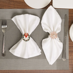 Detail of Christmas wreath and snowflake napkin rings with pearls and red bow accents