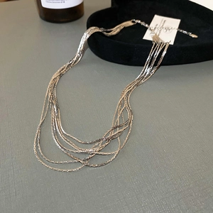 Detailaufnahme einer silbernen mehrlagigen Halskette mit filigranem Ketten-Design
