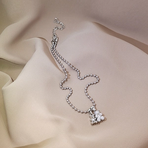Detailed macro of silver-tone ball chain necklace with sparkling floral cluster pendant