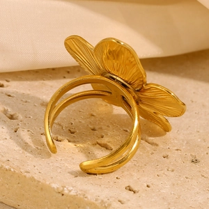Golden flower open ring in stainless steel with textured petals and adjustable band