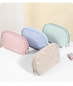 Detail of semi-circle PU cosmetic bags in four colors with floral jacquard texture