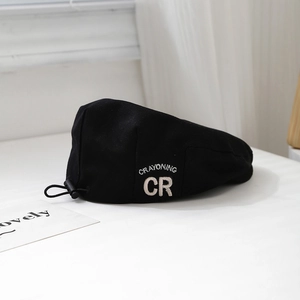 Detail of black canvas kids beret with CR embroidery and adjustable drawstring toggle
