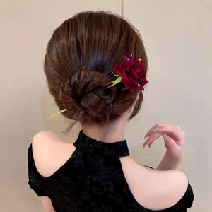 Elegant deep red rose hair pin with golden stem shown on a classic braided bun hairstyle