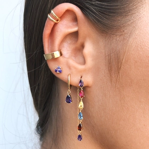 Close-up of golden tassel earrings with multi-colored teardrop cubic zirconia stones