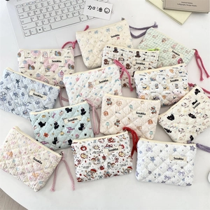 Detailed close-up of quilted floral cosmetic bags with cute teddy bear and cat patterns