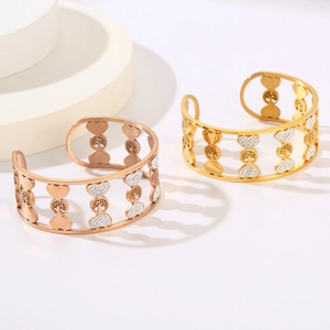 Detail of tree of life and heart patterns on rose gold and gold open bangles
