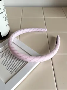 Detailed shot of a pink twill fabric headband displayed on a French minimalist background