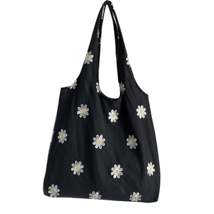 Black canvas tote bag with white daisy embroidery for casual summer street style