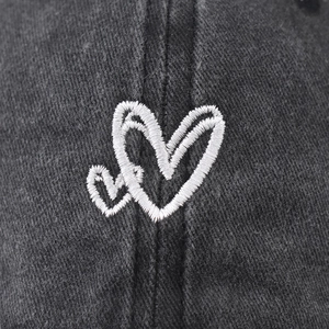 Washed black cotton baseball cap with white hand-drawn heart embroidery detail