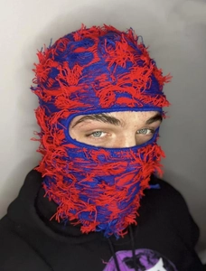 Close-up of red and blue distressed knit balaclava mask with fringe detail and frayed texture