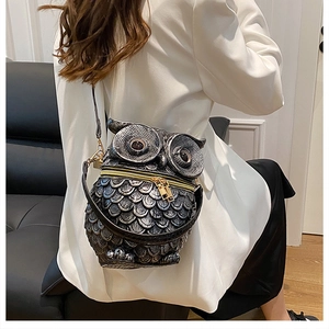Detailed view of owl-shaped crossbody bag with vintage silver feather textures on model