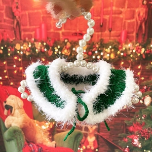 Detail of hand-knitted green pet Christmas collar with white faux fur and pearl hook