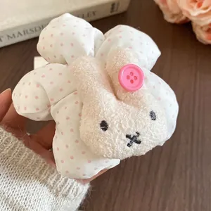 Cute white polka dot scrunchie featuring a plush bunny charm and pink button detail