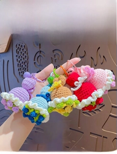 Detailed view of handmade crochet flower bouquet keychains with bells in five bright colors