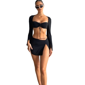 Women's black two-piece set with long sleeve halter crop top and side slit mini skirt
