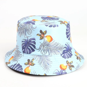 Close-up of tropical leaf prints on light blue canvas fabric of a reversible bucket hat