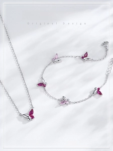Vue détaillée du collier et bracelet papillon en argent avec pierres roses