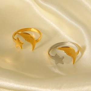 Detail of 18K gold and silver celestial open rings with star and moon motifs on silk