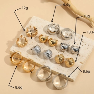 Titanium steel geometric hoop earrings in gold and silver set on stone display